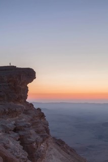 Mitzpe Ramon, Israel, Negev Desert, A woman in the vast overlooking the vast Makhtesh Ramon crater