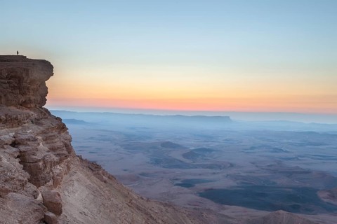 Mitzpe Ramon, Israel, Negev Desert, A woman in the vast overlooking the vast Makhtesh Ramon crater