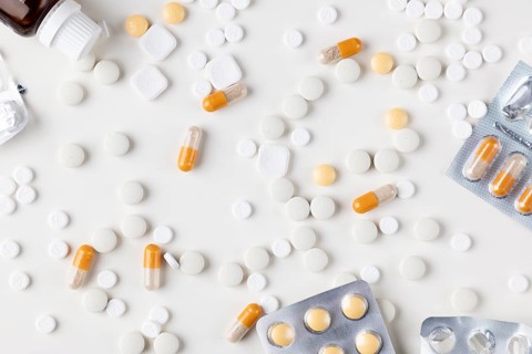 Different tablets and blister packs on a bright background