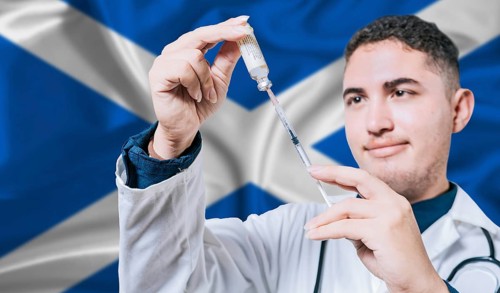 Doctor holding syringe on Scotland flag background. Medical professional holding syringe with