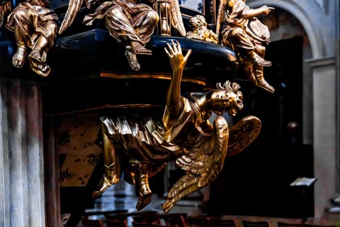 Richly decorated pulpit with intricate golden carvings, angel on the pulpit has symbolic meaning