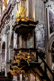 Richly decorated pulpit with intricate golden carvings, angel on the pulpit has symbolic meaning