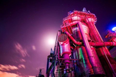 Violet-lit industrial building under bright night sky, Landschaftspark Duisburg Nord, Duisburg,