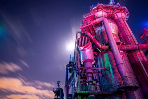 Industrial building in purple light under a starry night sky, Landschaftspark Duisburg Nord,