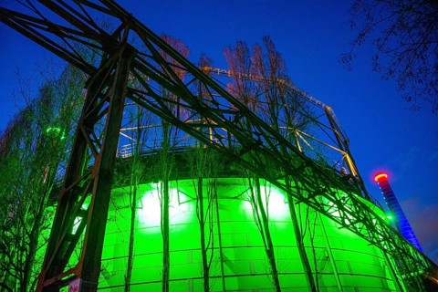 Industrial building illuminated at night in green with steel structures, Landschaftspark Duisburg