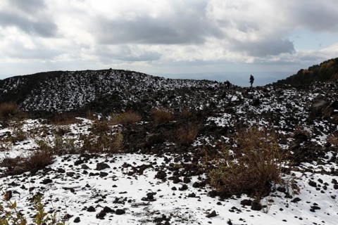 Barren volcanic landscape with remnants of snow, hikers, Etna, Etna, Catania, Sicily, Italy