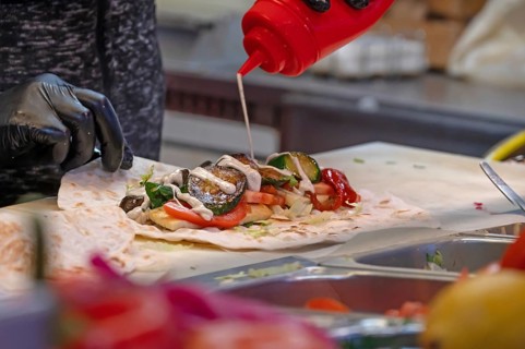 Preparation of falafel with vegetables and mayonnaise at a stand in the pedestrian zone, Nuremberg,