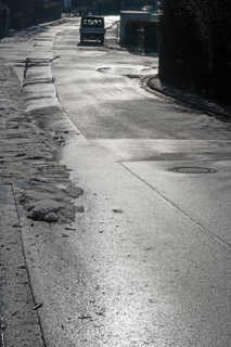 Remains of snow on rain-wet road against light, Eckental, Middle Franconia, Bavaria, Germany