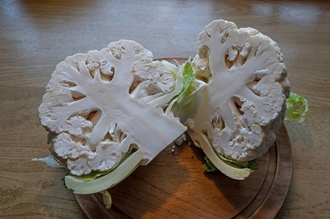 Halved cauliflower (Brassica oleracea var. botrytis) on a wooden board, Bavaria, Germany