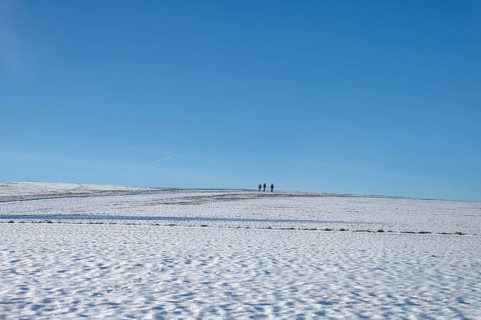 Snowy landscape with three hikers, blue sky, Beerbach, Middle Franconia, Bavaria, Germany