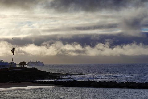 Dramatic scenery with clouds over the sea and a distant ship, Playa Blanca Lanzarote