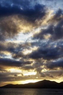 Dramatic sky during sunset, mountains in silhouette, light shows in the clouds, Puerto del Carmen