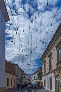 Light bulbs between houses for evening lighting, Cluj-Napoca, Transylvania, Romania
