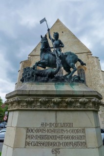 Sculpture of Saint George with dragons, in the back the Reformed Church in Wolfsgasse, Cluj-Napoca,