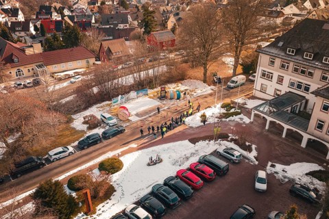 Aerial view of a people meeting on a snow-covered street and parking lot, fiberglass