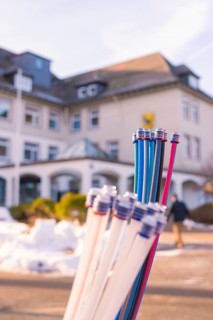 Colourful bundles of cables in front of a building and snow-covered ground, fibreglass