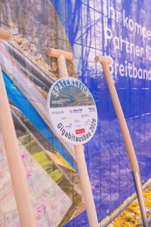 Spade in front of a poster referring to network expansion and construction, fiber optic