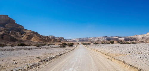 Sand track leads through the limestone gorge of Wadi Shuwaymiyah, Dhofar, Oman