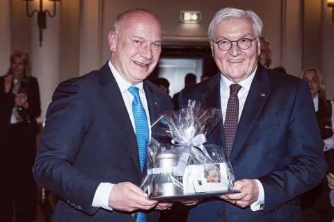 Kai Wegner and Frank-Walter Steinmeier with a gift in front of a dinner in honor of the Honorary