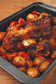 Pork knuckle, baked with vegetables, new potatoes, on a baking sheet, homemade, no people