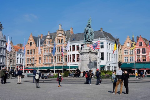 Market square Grote Markt with Jan Breydel and Pieter de Coninck monument and guild houses, Bruges,