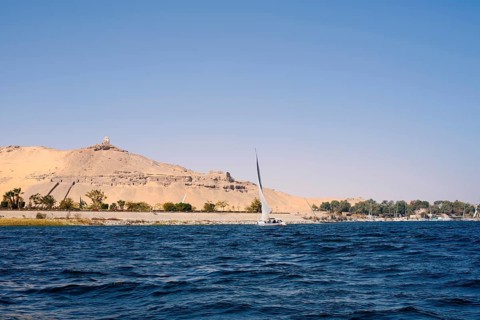 Qubbet el-Hawa with the rock tombs on the Nile, Aswan, Egypt