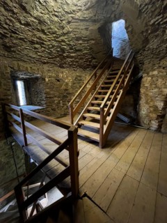 Modern wooden staircase for visitors tourists in keep made of quarry stone masonry Castle tower of