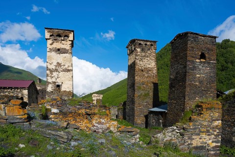 Stone towers in a historic village under clear blue sky in a hilly landscape, defensive towers,