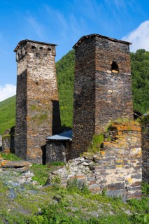 Two restored stone towers surrounded by nature and blue skies, defensive towers, Ushguli, Murqmeli