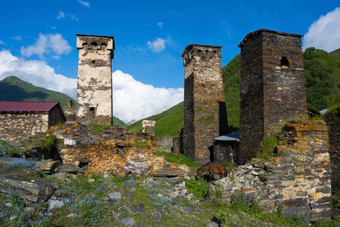Historic stone towers of a mountain village under clear blue sky, defensive towers, Ushguli,