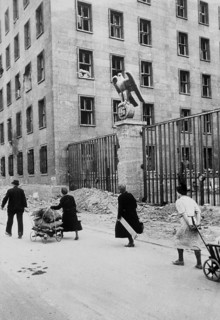 Civilians walk with their belongings in front of the Reich Ministry of Aviation in Wilhelmsstraße,