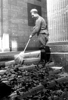 Soldier sweeping boxes of National Socialist medals from a staircase in the Reich Chancellery,