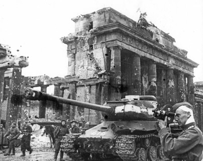Injured Soviet soldier with film camera in front of the Brandenburg Gate, May 1, 1945, Berlin,