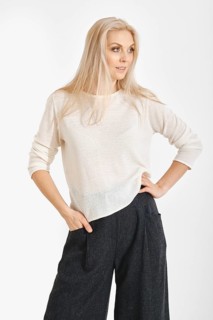 A woman stands confidently with one hand on her waist. They wear a light top and dark,