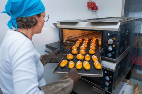 A baker pushes a sheet of golden rolls into the oven, bake rolls, Haselstaller Hof, Gechingen,