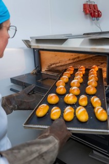 Baker holds a tray filled with evenly baked rolls, bake rolls, Haselstaller Hof, Gechingen, Germany