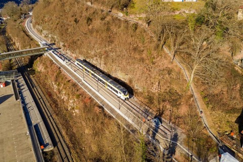 A train travels along a route near the forest, crosses a bridge, test run on the new Hermann-Hesse