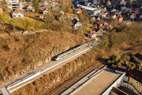 Overview of a train in a village with numerous houses and autumn landscape, test run on the new