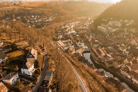 Small river town with train tracks and autumn tree scenery, test trip on the new Hermann-Hesse