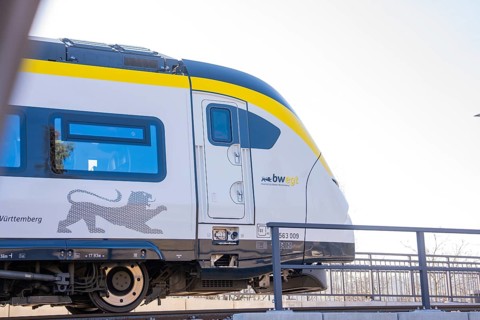 Modern yellow and white train on tracks in sunny surroundings, test run on the new Hermann-Hesse