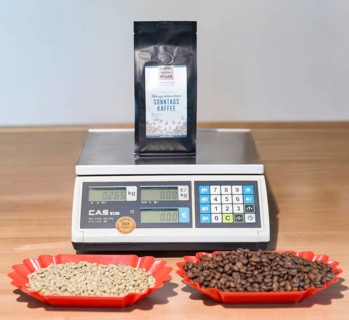 Scale with a bag of 250g ground coffee, plus the same amount of unroasted and roasted beans,