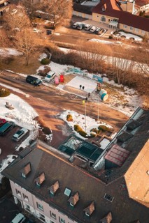 Bird's eye view of a snowy road with buildings and parked cars on a sunny winter day, Freudenstadt,