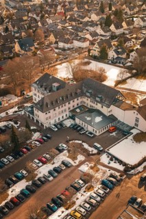 An overview of a building with addresses, parking lot and light snowfall, District Office,