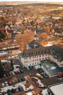 Urban scenery in winter with snow-covered houses and cloudless sky in warm lighting, District