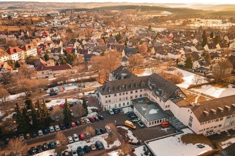 A part of a city with buildings, open parking areas and snow to see, District Office, Freudenstadt,