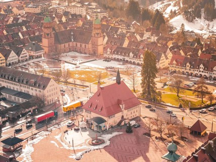 Central square with church and historic buildings in winter, light snow cover available,