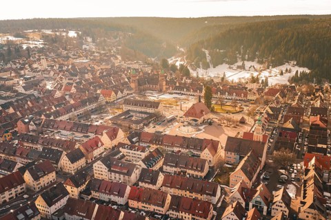 Winter cityscape with central square and red roofs surrounded by wooded hills, Freudenstadt, Black