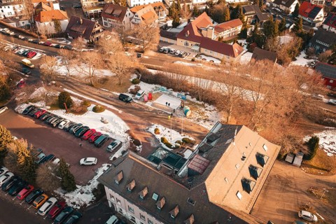 Bird's eye view of a snowy road with buildings and parked cars on a wintry day, Freudenstadt, Black