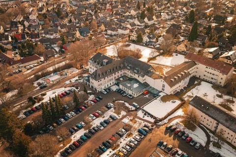 Comprehensive aerial view of a snowy city with cars and buildings in warm colors, district office,