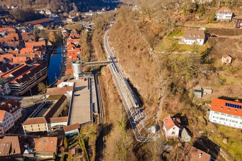 City panorama with train lines along a hill that run through an urban environment, test run on the